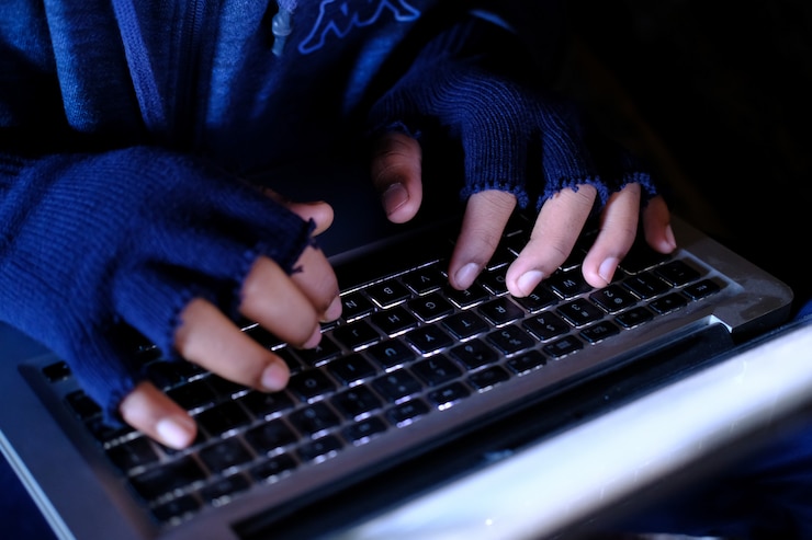 Foto hacker mano robando datos de la computadora portátil de arriba hacia abajo.