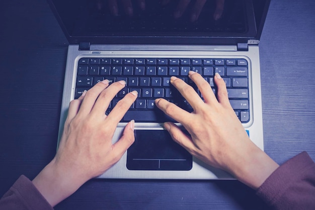 Hacker manos escribiendo en el teclado de la computadora portátil