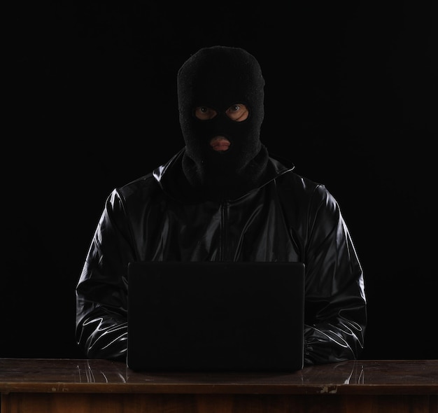 hacker mascarado encapuzado com laptop