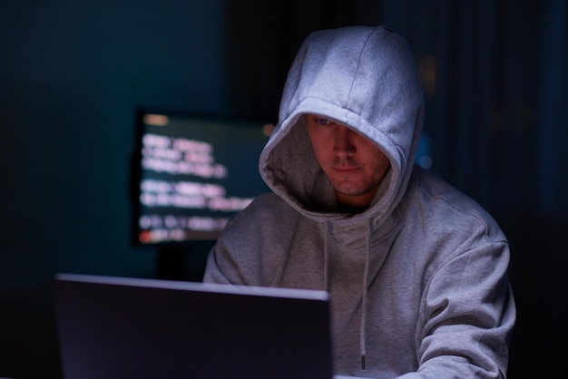 Hacker mit dem Computer Mann mit Kapuze bricht den Zugang, um Informationen zu stehlen und infiziert Computer und Systeme