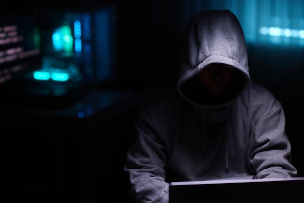 Hacker mit dem Computer Mann mit Kapuze bricht den Zugang, um Informationen zu stehlen und infiziert Computer und Systeme