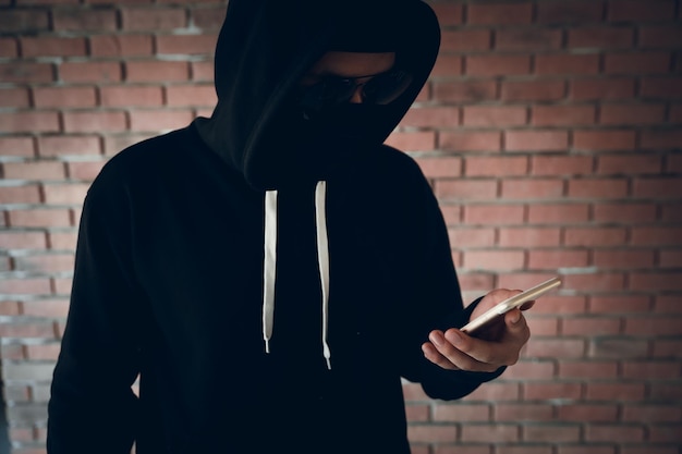 Hacker mit Handy gegen die Wand