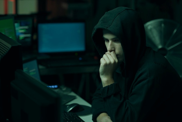 Hacker mit Hoodie, der mit einem Computer arbeitet