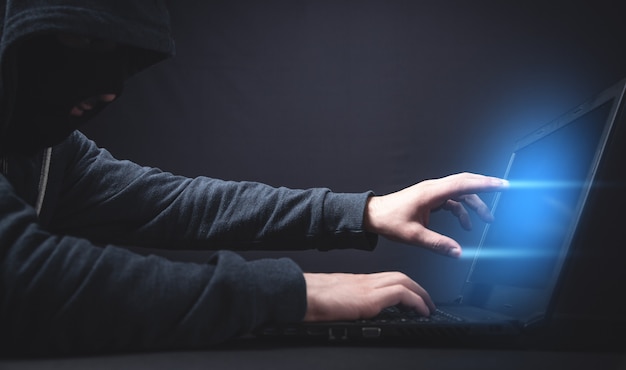 Hacker mit Laptop. Computerkriminalität