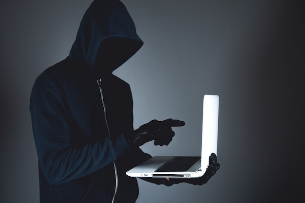 Hacker mit Laptop. Computerkriminalität.