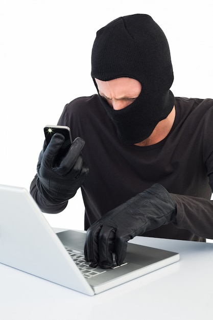 Hacker mit Laptop und Telefon