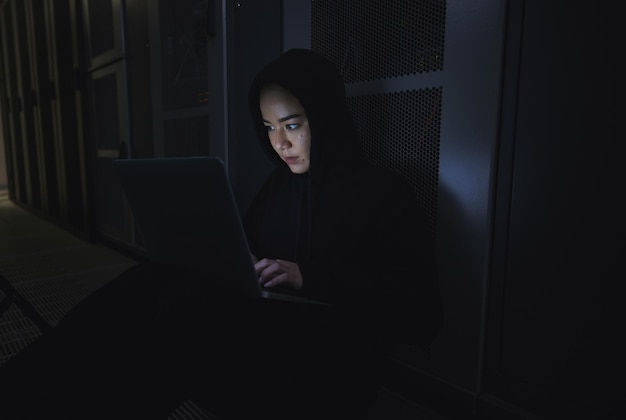 Hacker nocturno y programación con mujer y computadora portátil para software de codificación y seguridad cibernética Ransomware phishing y desarrollador con programadora en servidor para red de base de datos y delitos digitales