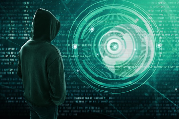 Hacker de pie sobre una pantalla con código binario