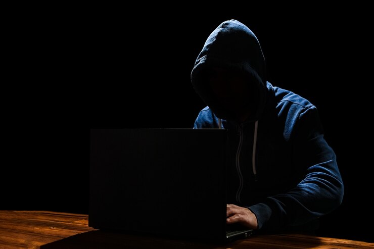 Foto un hacker con un portátil se sienta en una mesa y un código binario abstracto. programas virtuales de amenazas a la vida empresarial.
