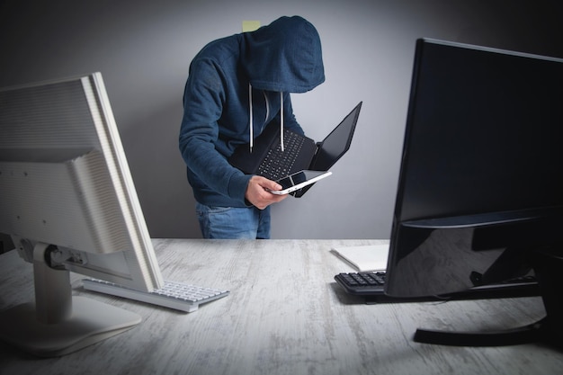 Hacker robando información de la computadora de la oficina Hacker criminal