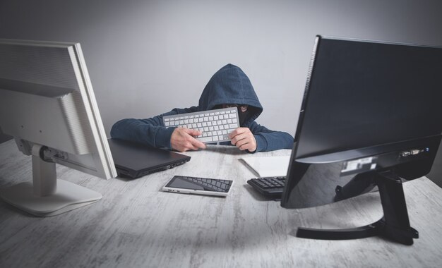 Hacker robando información de la computadora de la oficina. Piratería, Criminal
