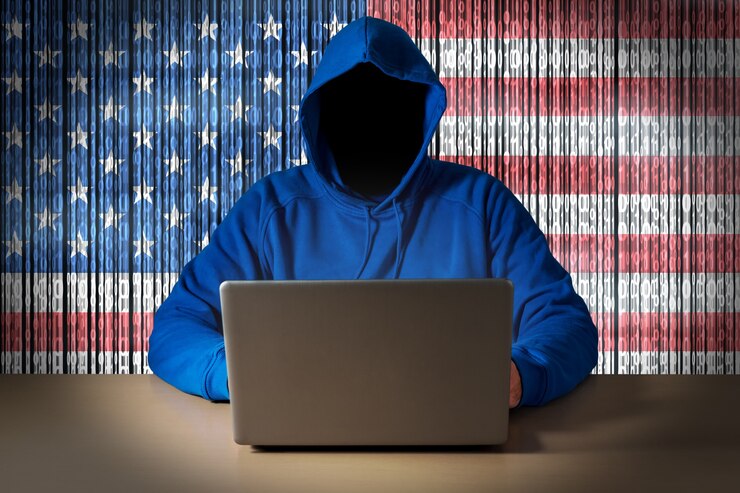 Foto hacker sentado frente a una computadora portátil en el fondo de la bandera digital de los estados unidos de américa