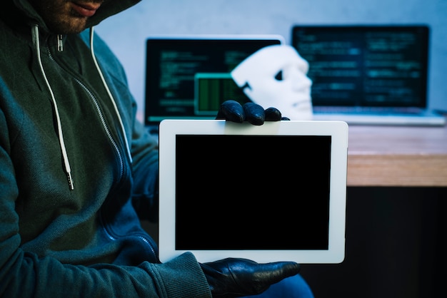 Foto hacker sujetando tableta