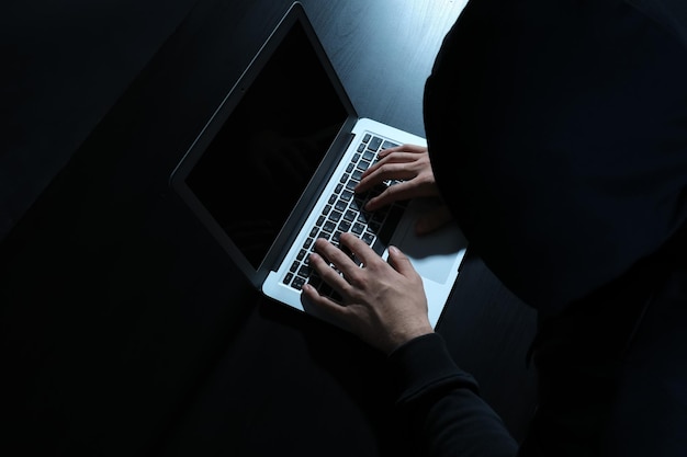 Hacker usando una laptop en la mesa