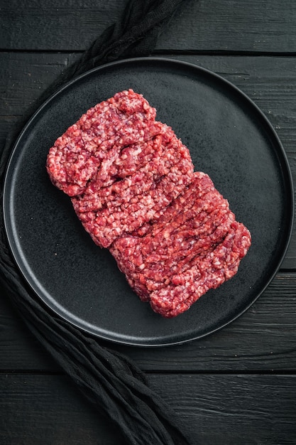 Hackfleisch. Hackfleisch mit Zutaten zum Kochen, auf schwarzem Holztisch Tisch, Draufsicht flach legen