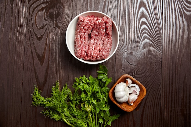 Hackfleisch mit frischen Gewürzen auf einem Holztisch