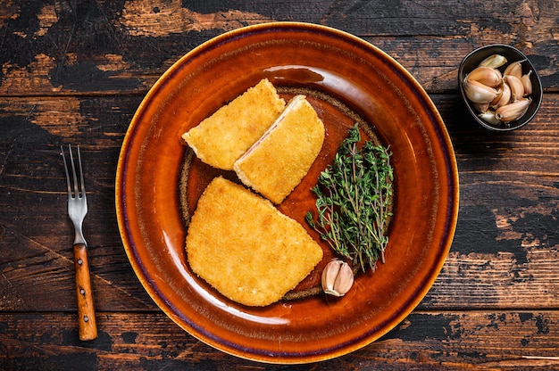 Hähnchen-Cordon-Bleu-Fleisch-Rollenkotelett mit Schinken und Käse. Dunkler hölzerner Hintergrund. Ansicht von oben.