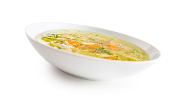 Hähnchen- oder Rindfleischsuppe mit Nudeln, Karotten und Petersilienkraut, isoliert auf weiss.