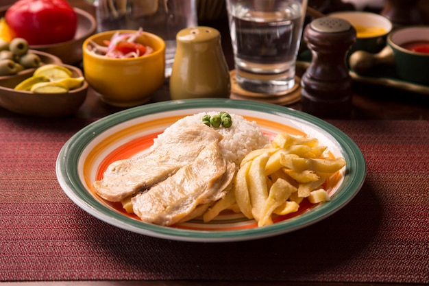 Hähnchenbrustfilet pommes frites peruanisches traditionelles essen mise en place holztisch