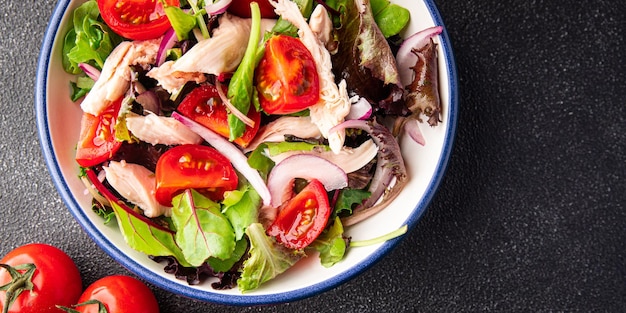 hähnchenfleischsalat tomate, grüner salat, zwiebel gesunder essenssnack auf dem tischkopienraum