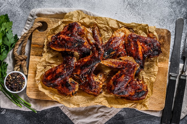 Hähnchenflügel grillen. Bauernhof Bio-Fleisch. Draufsicht. Grauer Hintergrund