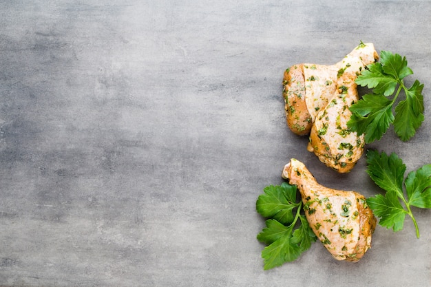 Hähnchenmarinade Beine, frisches Gemüse auf einer grauen Oberfläche. Draufsicht.