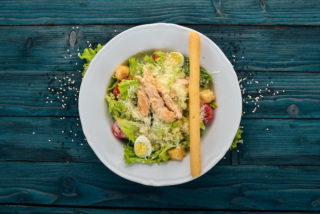 Hähnchensalat und frisches Gemüse Caesar Draufsicht auf blauem Holzhintergrund Kopierbereich