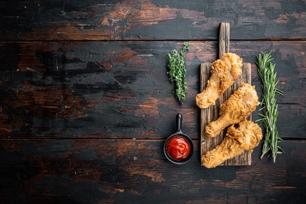 Hähnchenschenkel paniert und auf dunklem Holz gebraten