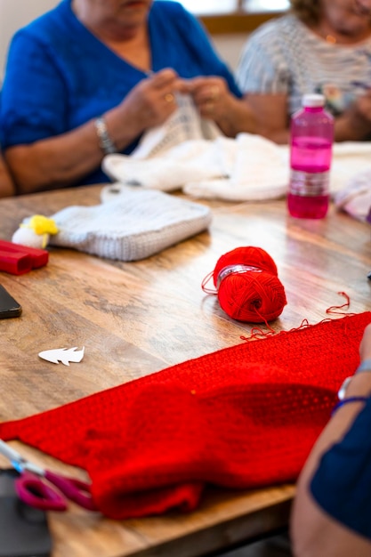 Häkelclub Vertikales Bild einer Häkelarbeit in leuchtend roter Farbe