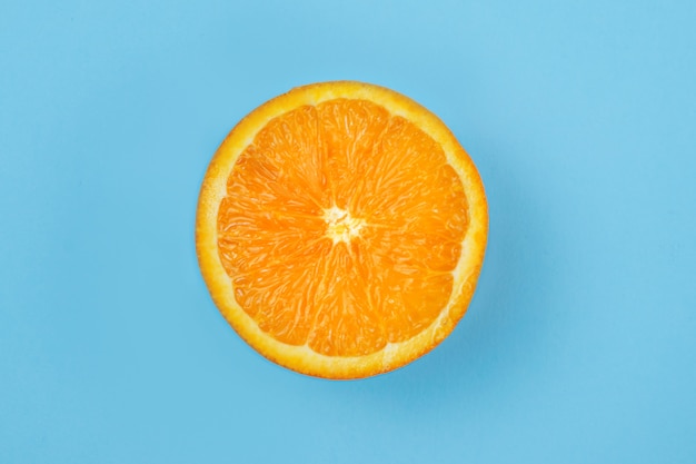 Hälfte eine saftige frische orange auf einem blauen nahaufnahmehintergrund