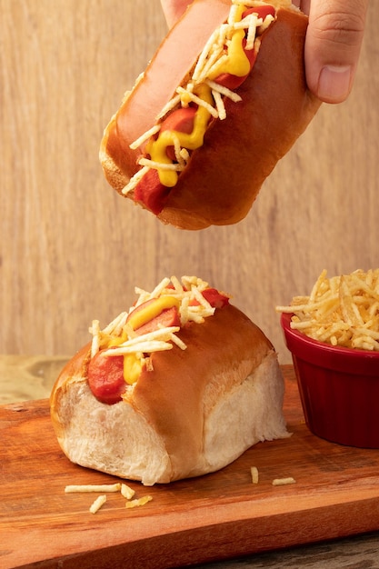 Hält köstlichen Mini-Hotdog Selektiver Fokus