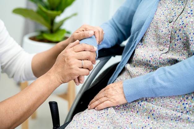 Händchen haltend asiatische ältere Patientin mit Liebespflege ermutigen und Empathie