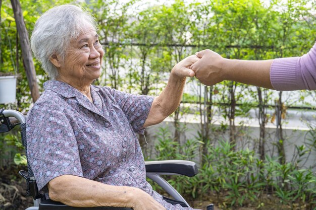 Händchen haltend Asiatische Seniorin oder ältere Patientin der alten Dame mit Liebe, Fürsorge, Ermutigung und Empathie im Park.