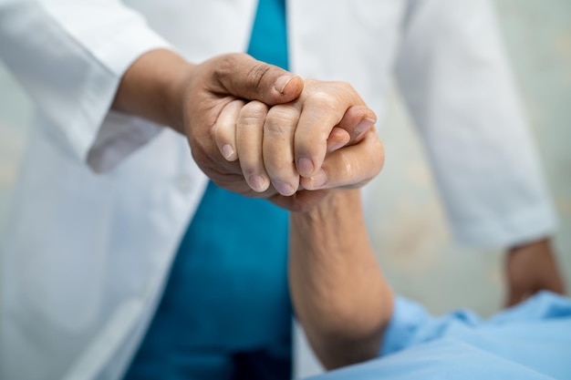 Händchen haltend Asiatische Seniorin oder ältere Patientin der alten Dame mit Liebespflege ermutigen und Empathie auf der Krankenstation gesundes starkes medizinisches Konzept