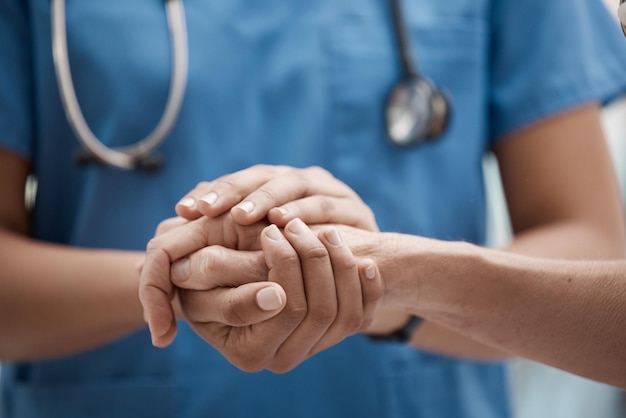 Händchenhaltende Mitarbeiter und Krankenhausgemeinschaft mit vertrauensvoller Unterstützung und Hoffnung in einer Klinik Krankenschwester Arzt und Arbeiter Hände zusammen, um Arbeitssolidarität und Teamkomfort Pflege zu zeigen