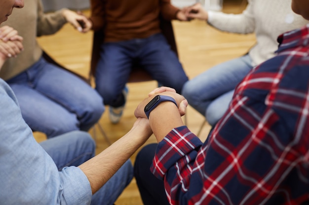 Händchenhaltende Personen in der Selbsthilfegruppe