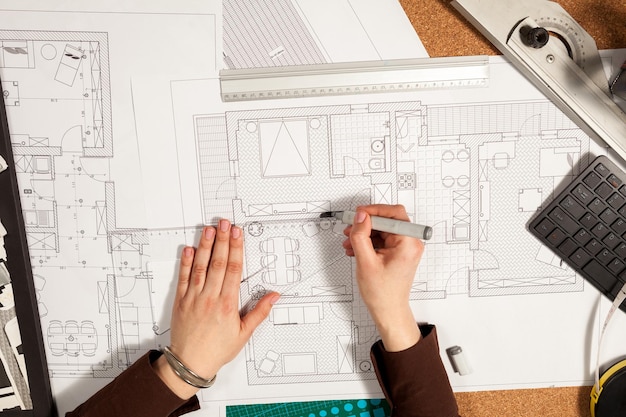 Hände auf Blaupausen auf einem Architektentisch. Bau und Architektur. Projekt und Design