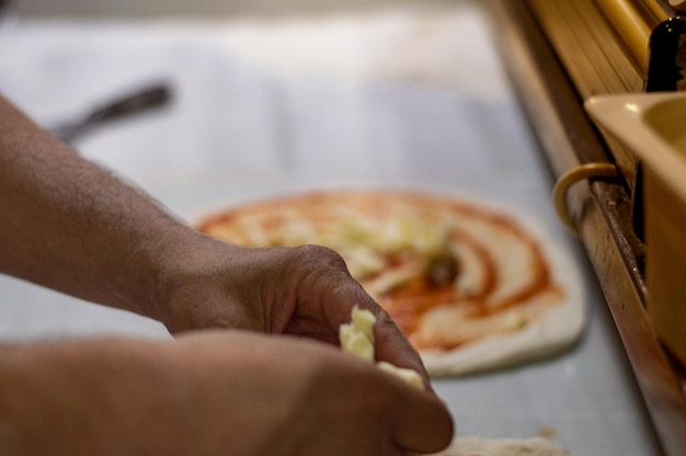 Hände bereiten Pizza zu