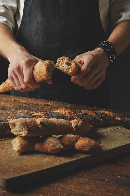 Hände brechen und trennen frisches Bio-Baguette