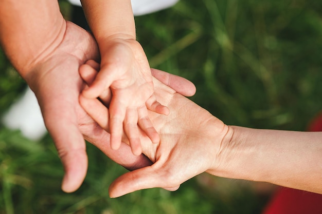 Hände der Familienmitglieder, die übereinander liegen, Liebe, Zusammenhalt, Glück in der Familie.