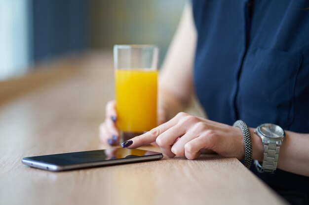 Hände der Frau, mit Smartphone im Café