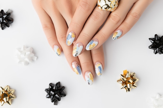 Hände der jungen erwachsenen Frau mit modischen Nägeln auf weißem Hintergrund. Frühling Sommer Nageldesign. Maniküre, Pediküre Schönheitssalon Konzept.