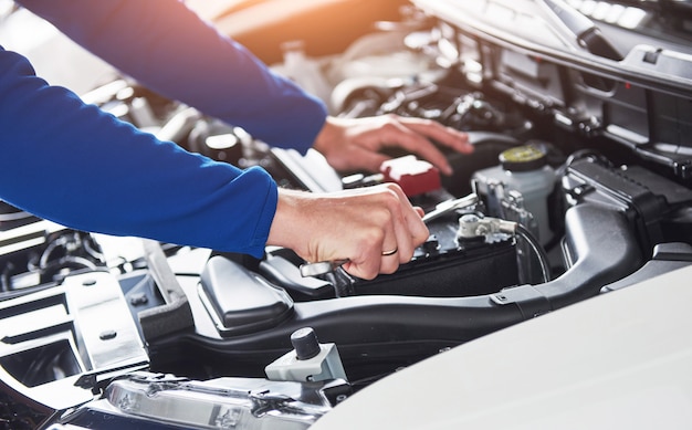 Hände des Automechanikers mit Schlüssel in der Garage