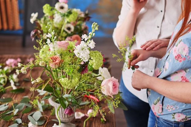 Hände des Floristen sammeln Hochzeitsblumenstrauß. Florist bei der Arbeit