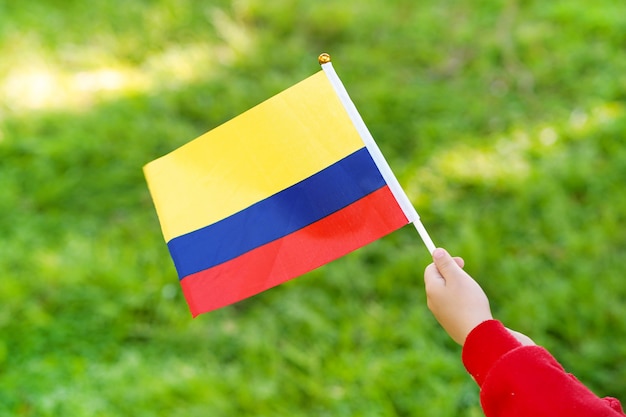 Hände des kleinen Mädchens halten Venezuelas Flagge