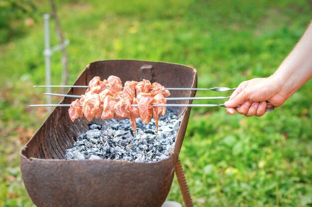 Hände des Mannes bereitet Grillfleisch zu