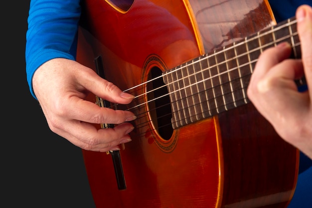 Hände des Musikers, der auf klassischer Gitarre spielt