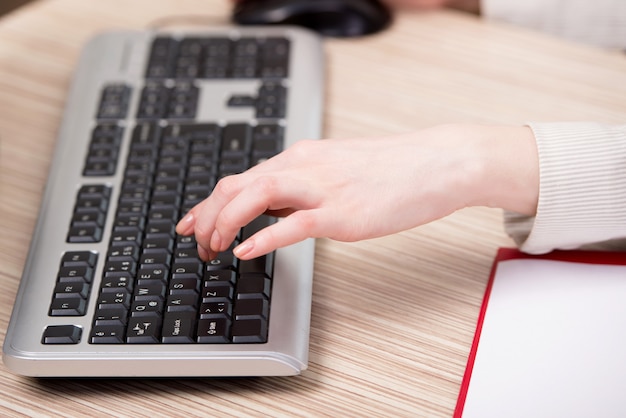 Hände, die an der Tastatur im Büro arbeiten