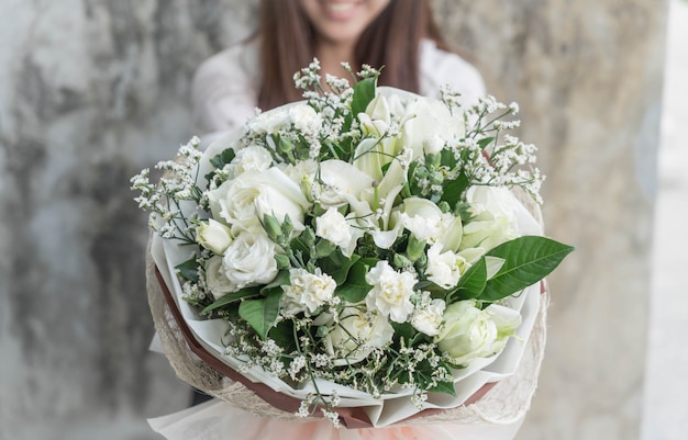 Hände, die Blumenstrauß der Blume halten