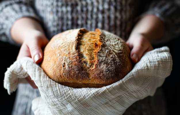 Hände, die ein frisch gebackenes Brot in einer gemütlichen Küche halten